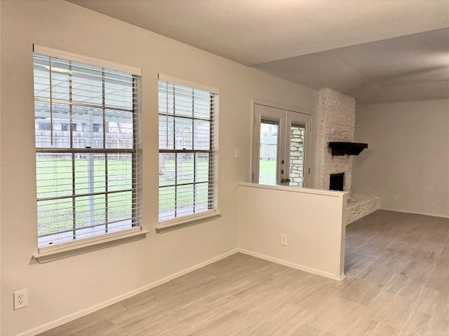 12104 Sage Hen Cir, Austin, TX 78727 - spare room with a fireplace, healthy amount of natural light, and wood finished floors