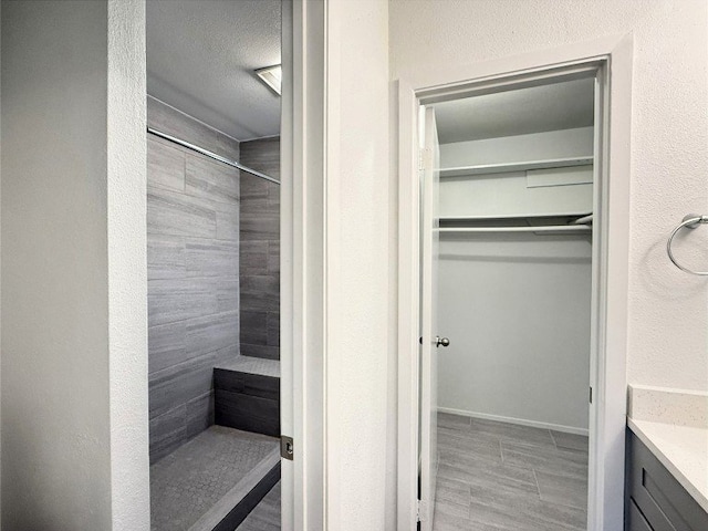 12104 Sage Hen Cir, Austin, TX 78727 - full bath with tiled shower, vanity, and a walk in closet
