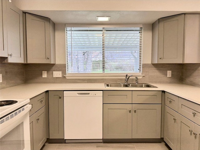 12104 Sage Hen Cir, Austin, TX 78727 - kitchen with white appliances, gray cabinetry, light countertops, and backsplash