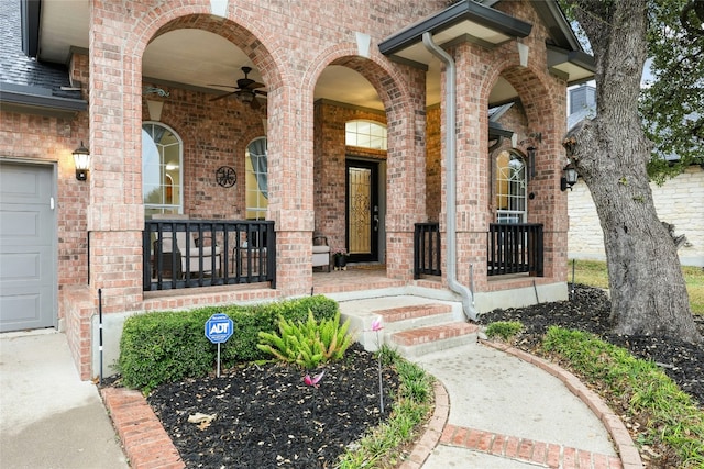 doorway to property featuring a garage, ceiling fan, and covered porch