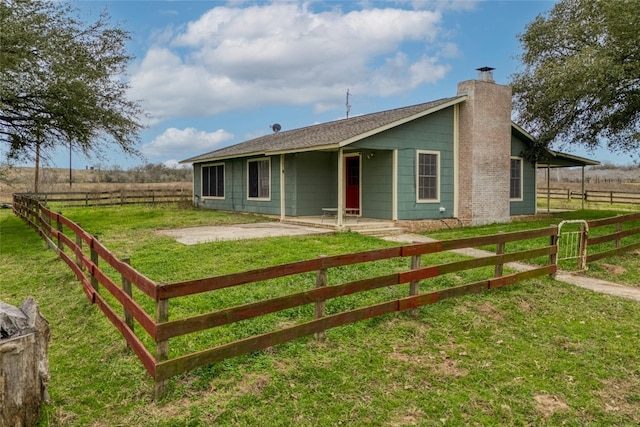 rear view of property with a yard and a rural view