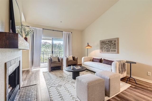 living room with high vaulted ceiling and light wood-type flooring