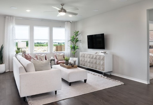 living room featuring dark wood-type flooring and ceiling fan