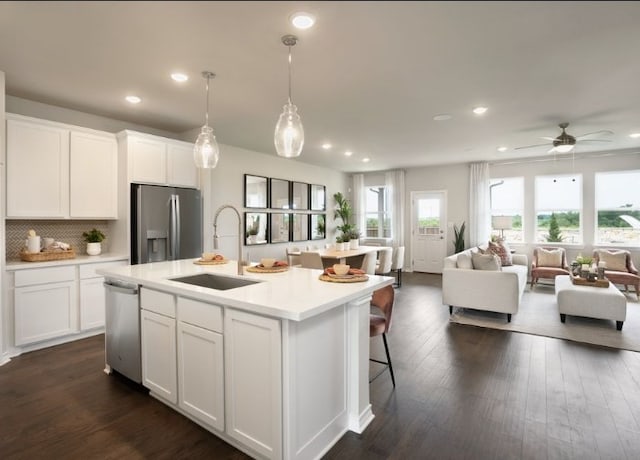 kitchen with a kitchen island with sink, sink, white cabinets, and appliances with stainless steel finishes