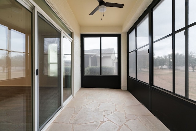 unfurnished sunroom featuring ceiling fan