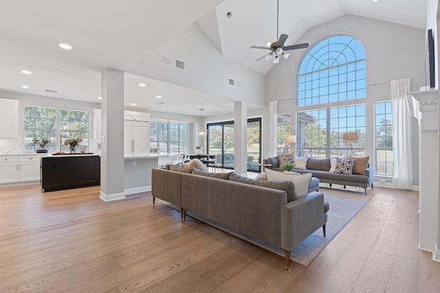 living room featuring ceiling fan, high vaulted ceiling, and light hardwood / wood-style floors