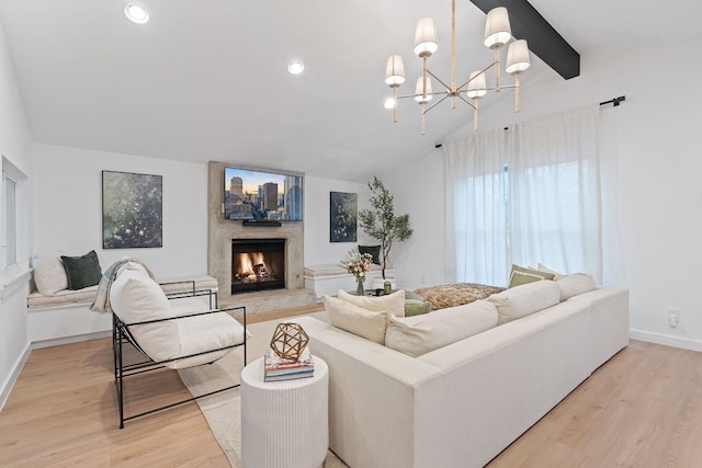 living room with lofted ceiling with beams, light wood-type flooring, a chandelier, and a fireplace