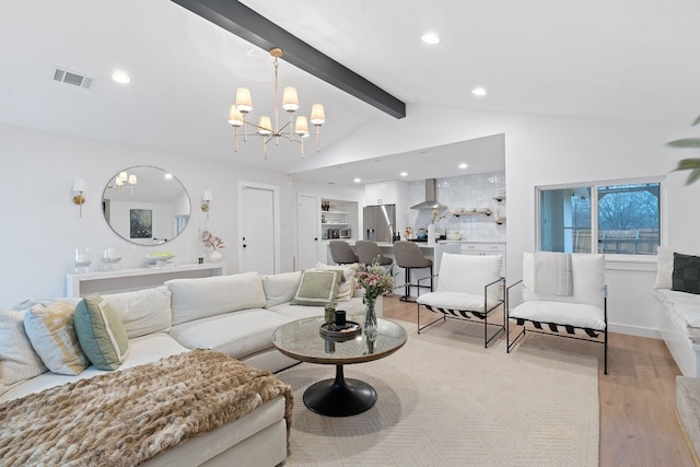 living room with a notable chandelier, lofted ceiling with beams, and light wood-type flooring