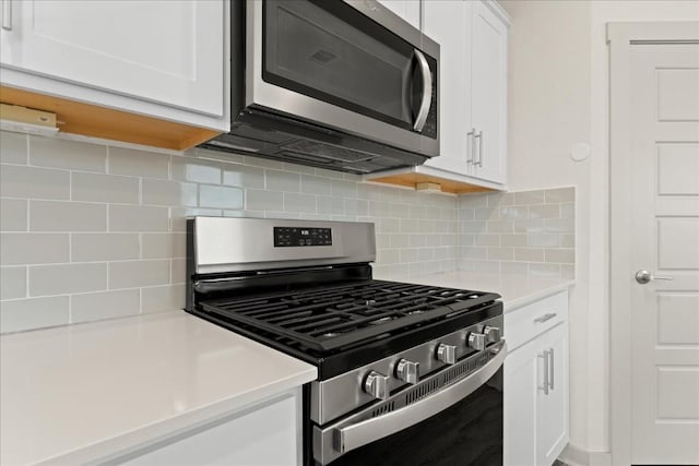 kitchen featuring white cabinetry, appliances with stainless steel finishes, and backsplash