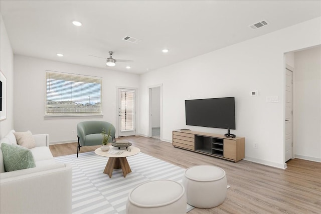 living room with ceiling fan and light hardwood / wood-style flooring