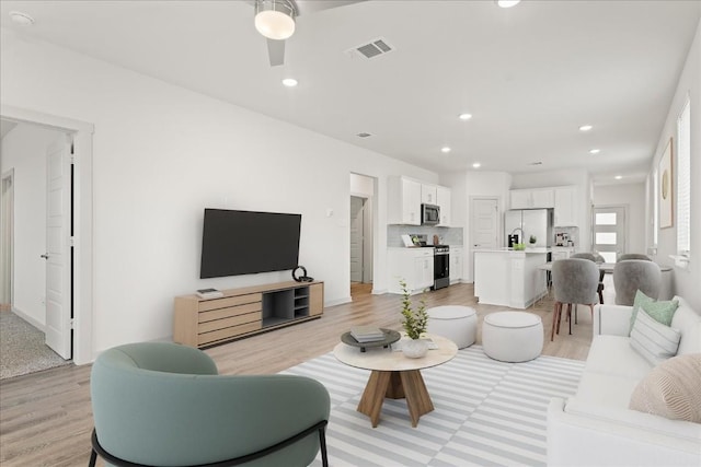 living room featuring ceiling fan and light wood-type flooring