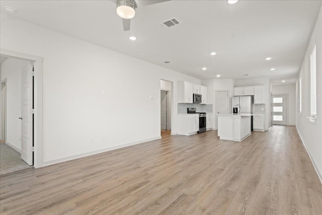 unfurnished living room featuring ceiling fan and light wood-type flooring