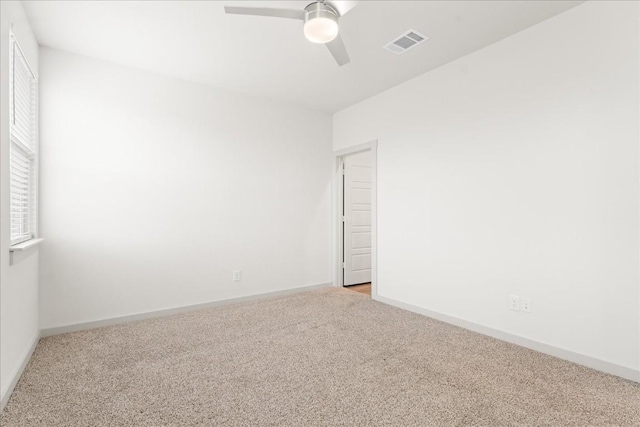 carpeted spare room featuring ceiling fan