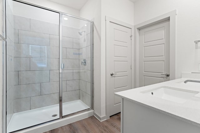 bathroom with walk in shower, wood-type flooring, and vanity