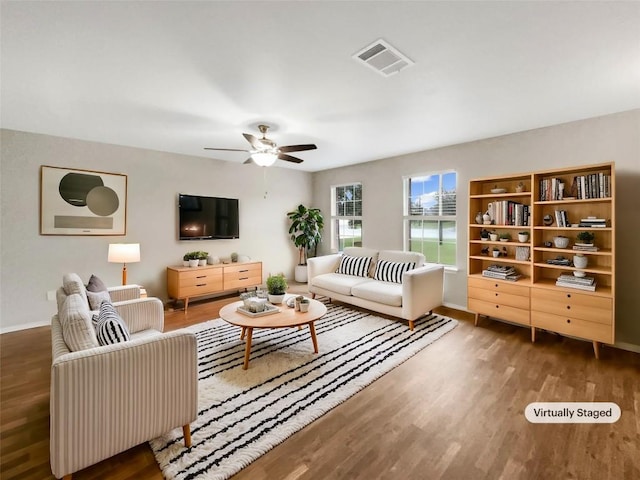 living room featuring dark wood-type flooring and ceiling fan