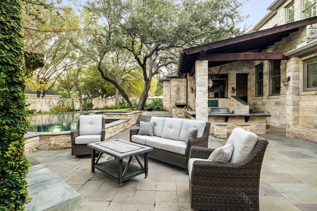 view of patio with a water view and an outdoor living space with a fireplace