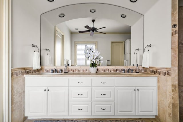 bathroom with tile walls, ornamental molding, vanity, and ceiling fan