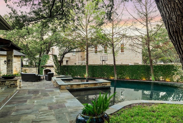 view of home's community featuring a pool with hot tub, a patio, and an outdoor living space with a fireplace