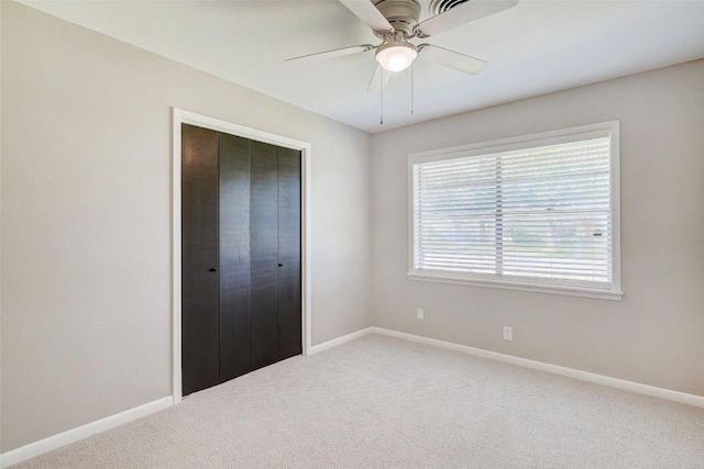 unfurnished bedroom featuring carpet floors, ceiling fan, and a closet