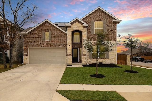 front facade with a yard, a garage, and solar panels