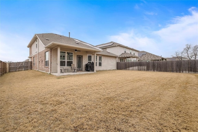 rear view of property featuring a patio, ceiling fan, and a lawn