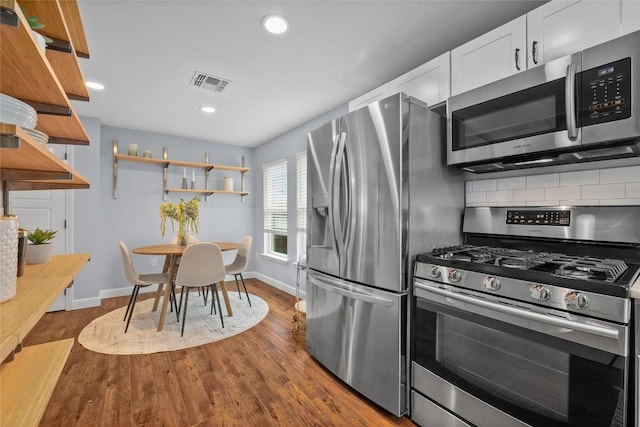 1191 Chicon St, Austin, TX 78702 - kitchen featuring stainless steel appliances, open shelves, backsplash, white cabinets, and dark wood-style floors