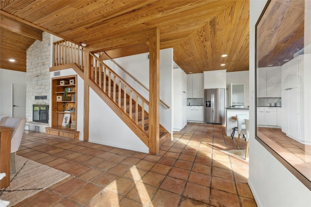 unfurnished living room with lofted ceiling, wooden ceiling, and a fireplace