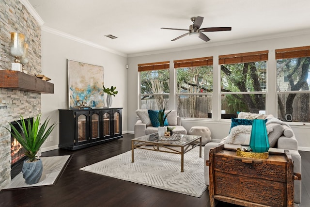 interior space featuring dark hardwood / wood-style flooring, ornamental molding, a large fireplace, and ceiling fan