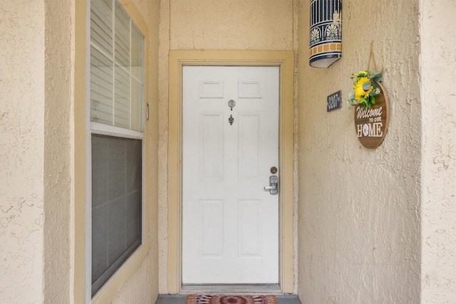 doorway to property with stucco siding