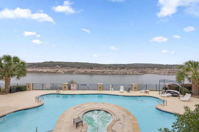 community pool with a patio area, a community hot tub, a water view, and fence