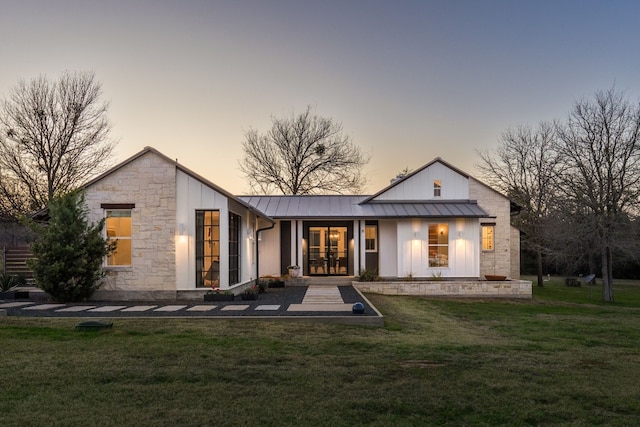 back house at dusk featuring a yard