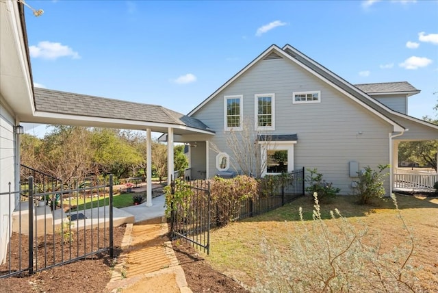 rear view of property featuring a lawn