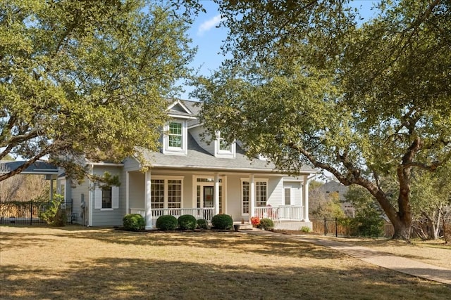 new england style home featuring a porch and a front lawn