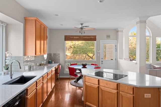 kitchen with sink, a center island, decorative columns, decorative backsplash, and black appliances