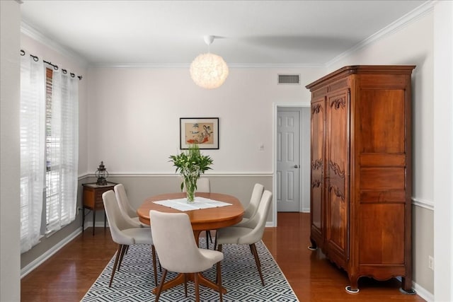 dining space featuring dark wood-type flooring and ornamental molding