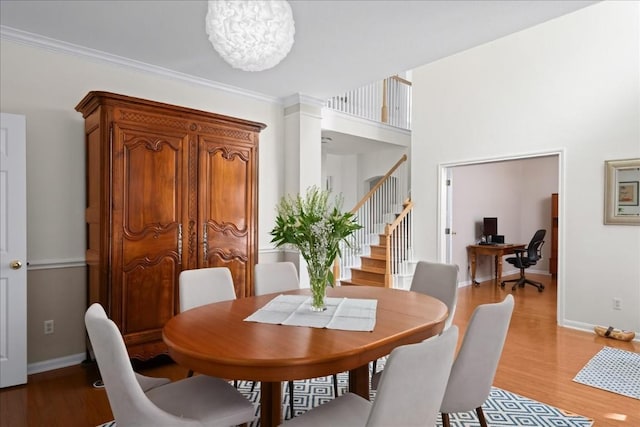 dining room with a notable chandelier, crown molding, and light wood-type flooring