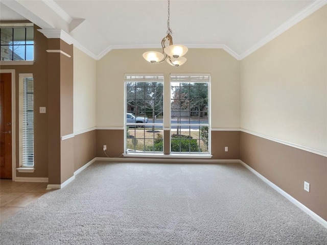 empty room featuring an inviting chandelier, carpet floors, vaulted ceiling, and ornamental molding