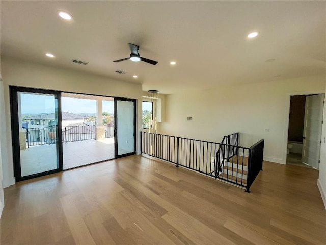 empty room with ceiling fan and light wood-type flooring