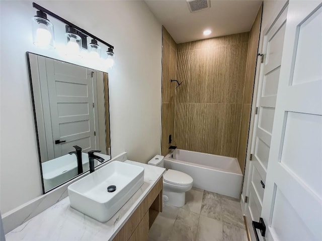 full bathroom featuring vanity, tiled shower / bath combo, and toilet