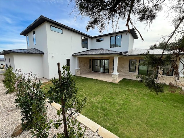 rear view of property with a lawn and a patio area