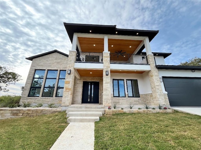 contemporary house featuring ceiling fan, a balcony, a garage, and a front yard