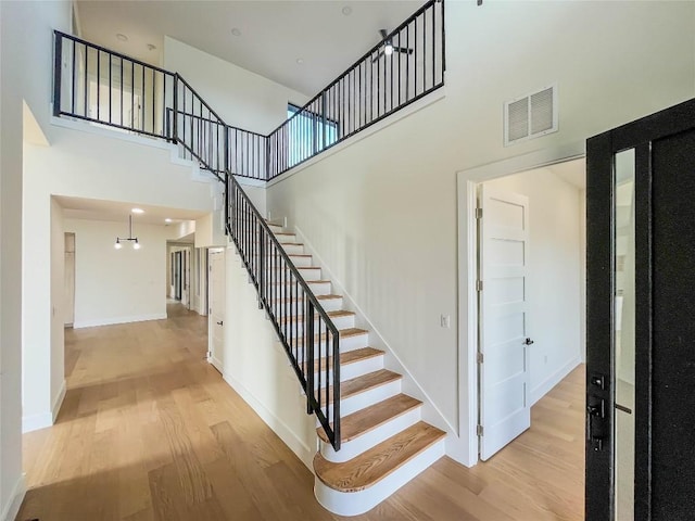 stairway with a high ceiling and wood-type flooring