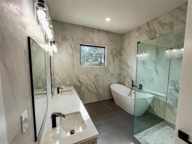 bathroom featuring vanity, tile patterned flooring, a bathtub, and tile walls