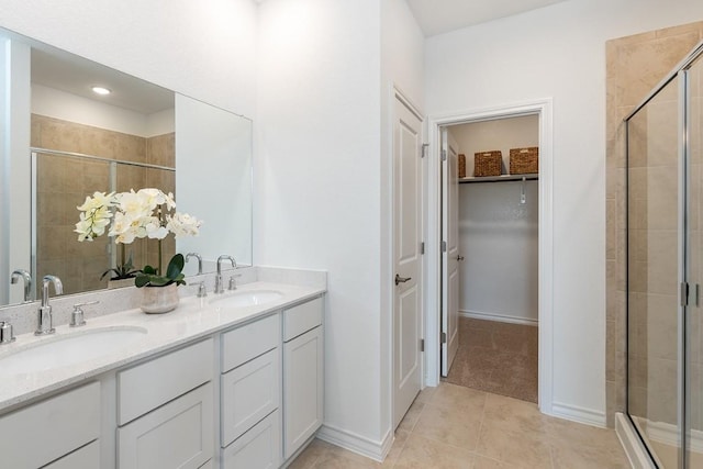 bathroom with tile patterned flooring, vanity, and walk in shower