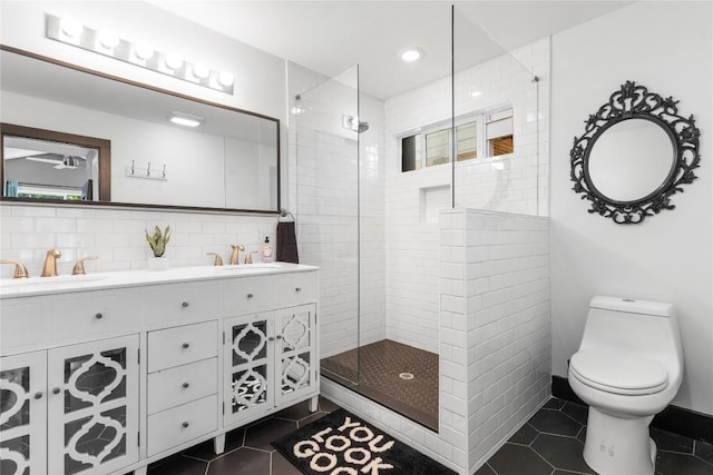 bathroom featuring tiled shower, tile patterned floors, toilet, and a wealth of natural light