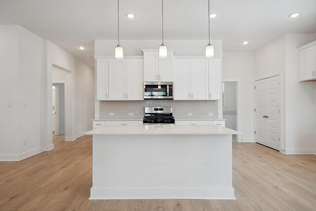 137 Tenny Ln, Kyle, TX 78640 - kitchen featuring appliances with stainless steel finishes, decorative backsplash, light countertops, baseboards, and recessed lighting