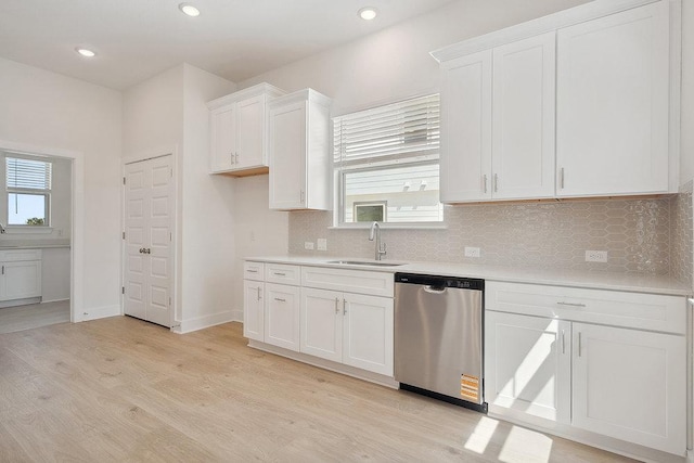 137 Tenny Ln, Kyle, TX 78640 - kitchen with stainless steel dishwasher, light countertops, backsplash, white cabinets, and recessed lighting