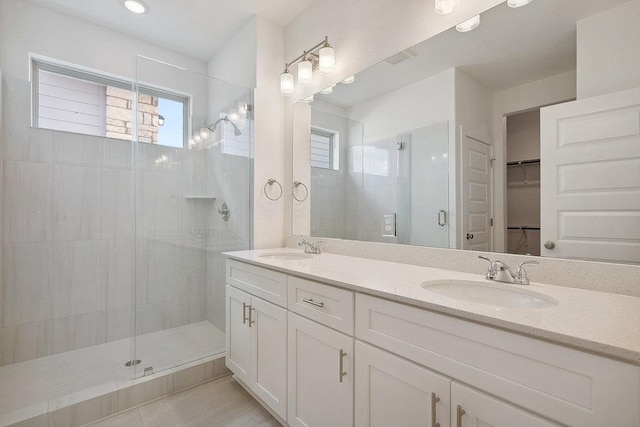 137 Tenny Ln, Kyle, TX 78640 - full bathroom with healthy amount of natural light, a shower stall, tile patterned floors, and a walk in closet