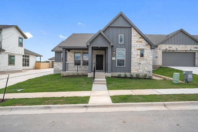 137 Tenny Ln, Kyle, TX 78640 - view of front facade with board and batten siding, stone siding, concrete driveway, and a garage