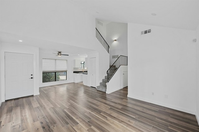 unfurnished living room with hardwood / wood-style flooring and high vaulted ceiling